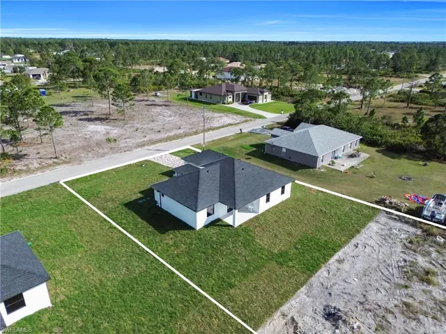 Aerial perspective of suburban area featuring a heavily wooded area