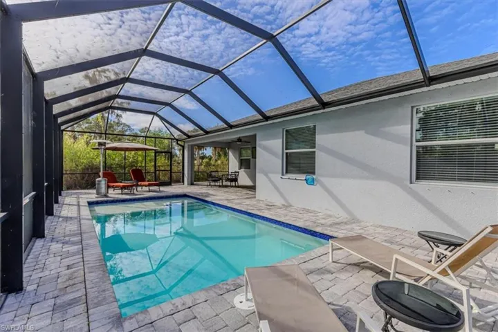 Outdoor pool with a sunroom, a patio area, and a lanai