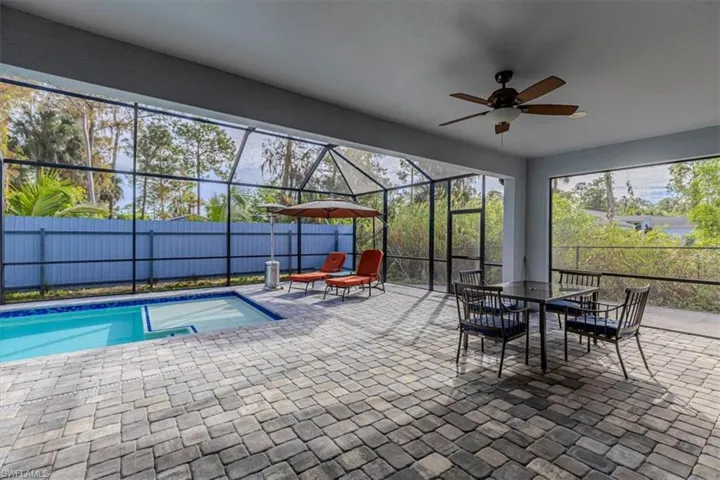 View of pool with a patio area, outdoor dining area, a lanai, and a sunroom