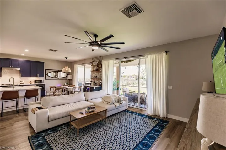 Living room featuring ceiling fan, sink, and wood-type flooring