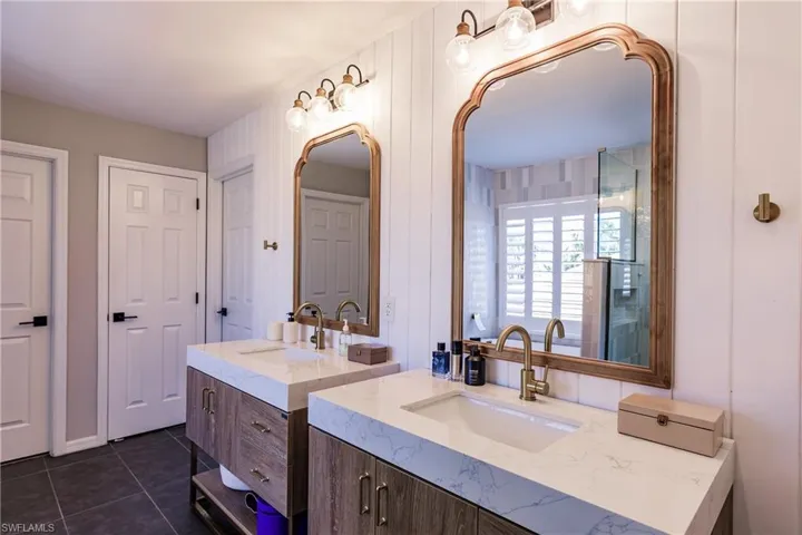 Bathroom featuring tile flooring, oversized vanity, and dual sinks