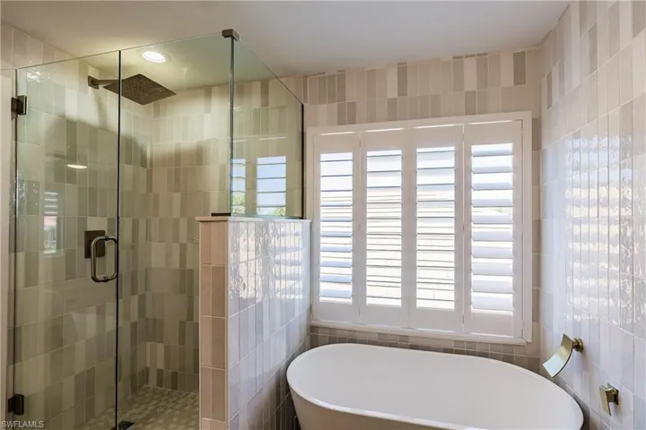 Bathroom with tile walls and shower with separate bathtub