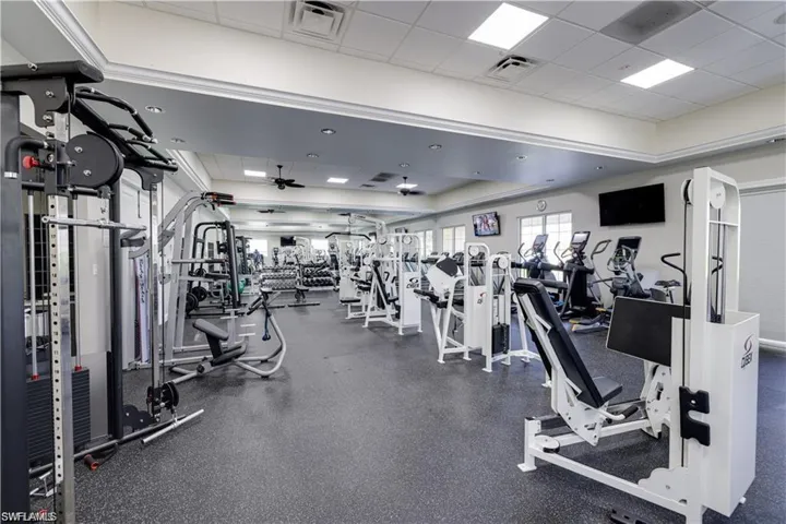 Exercise room with a paneled ceiling and ceiling fan