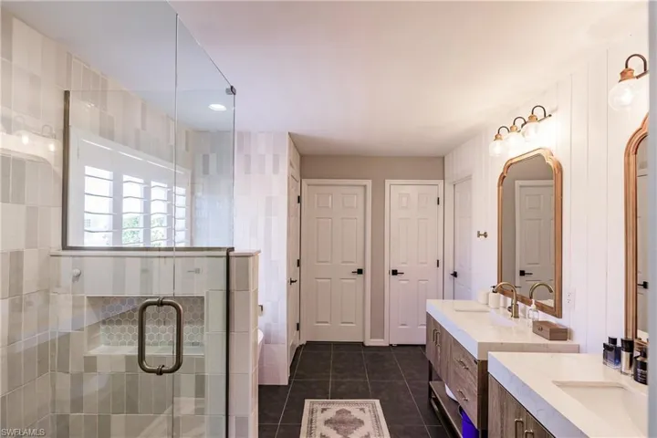 Bathroom featuring tile floors, dual sinks, and large vanity