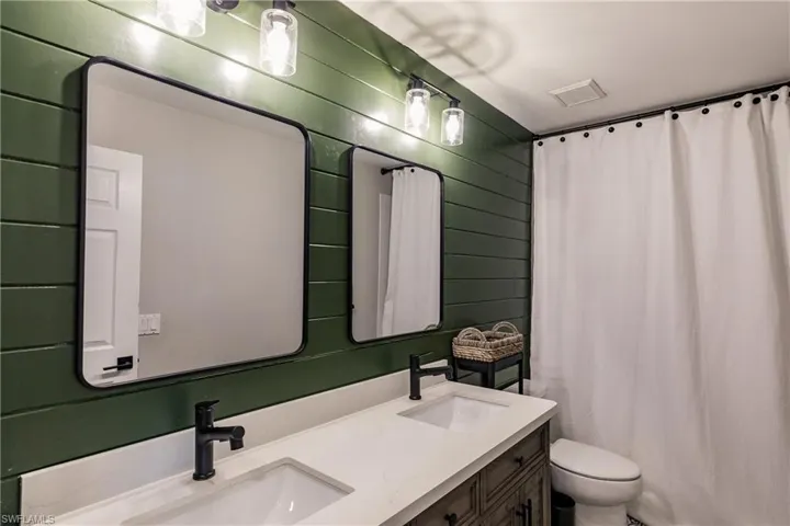 Bathroom with dual bowl vanity and toilet
