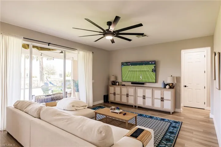 Living room with ceiling fan and light wood-type flooring
