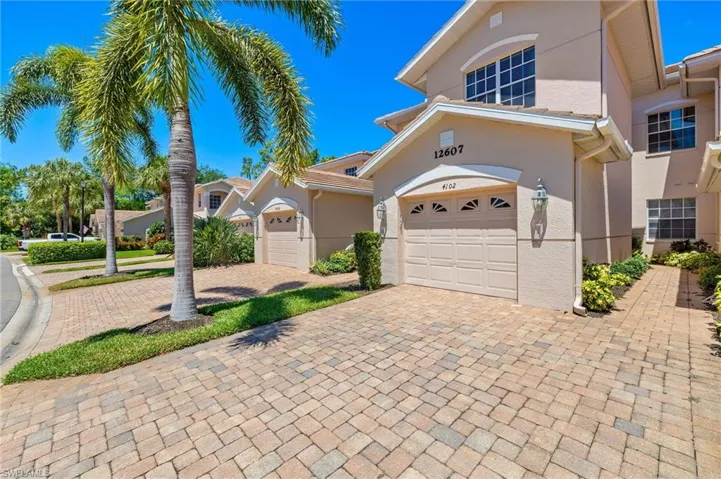 View of front of house with decorative driveway and stucco siding