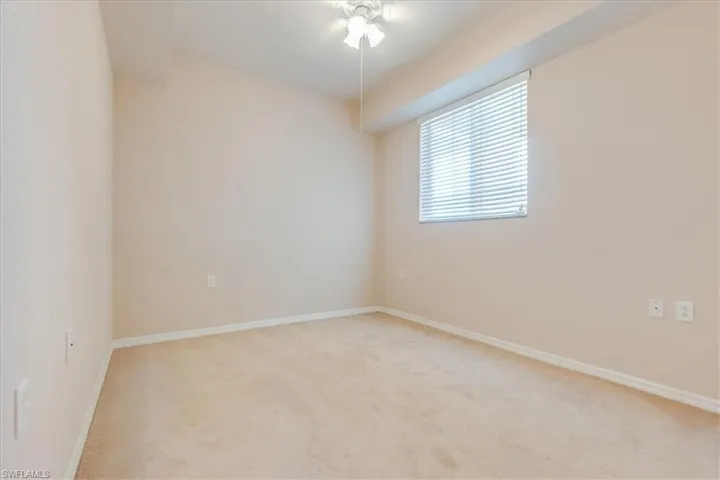 Guest bedroom with a window and ceiling light/fan.