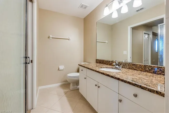 Primary bathroom with tile patterned flooring, vanity, and toilet.