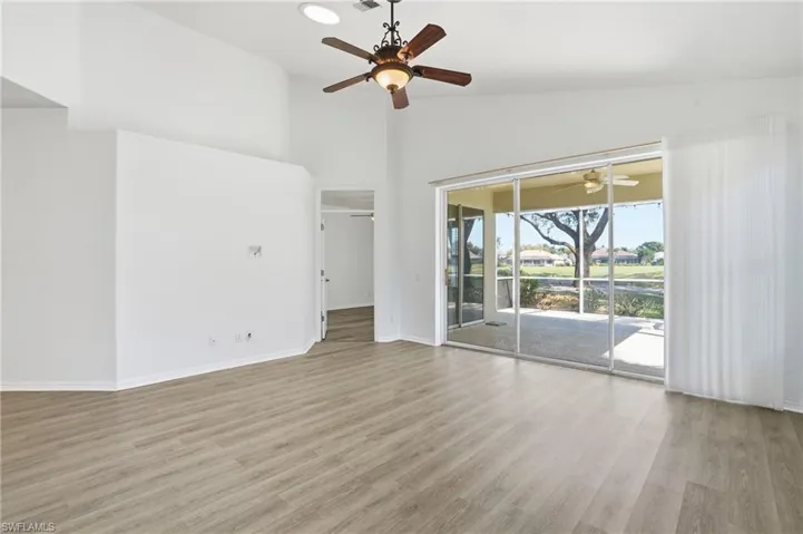 Unfurnished room with light wood-style floors and a high ceiling