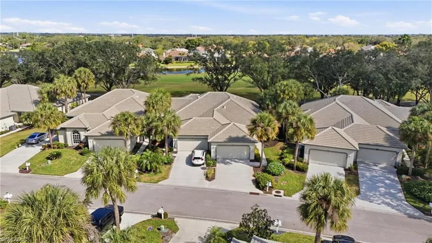 Aerial view of residential area with a nearby body of water and a golf club
