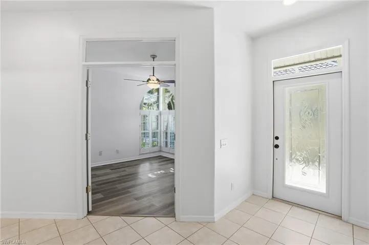 Entrance foyer with ceiling fan and light tile patterned floors