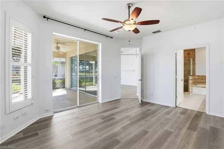 Unfurnished bedroom with ceiling fan, light wood-style flooring, access to outside, and ensuite bathroom