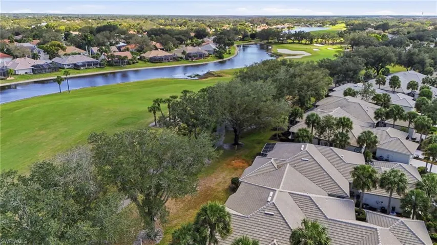 Aerial perspective of suburban area with a golf club and a nearby body of water