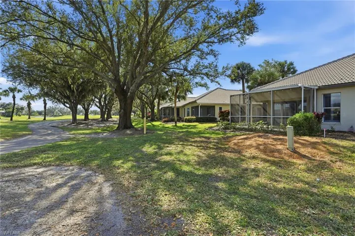 View of green lawn featuring a sunroom and glass enclosure