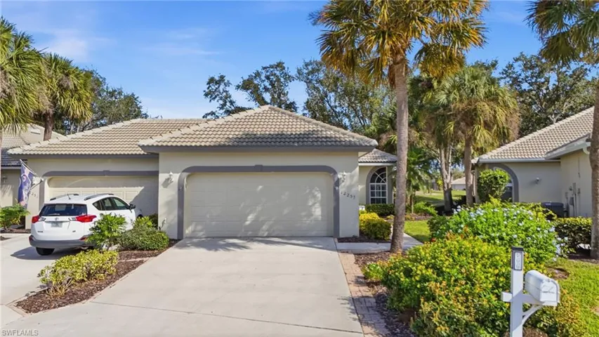 View of front of house with concrete driveway, stucco siding, a tile roof, and a garage