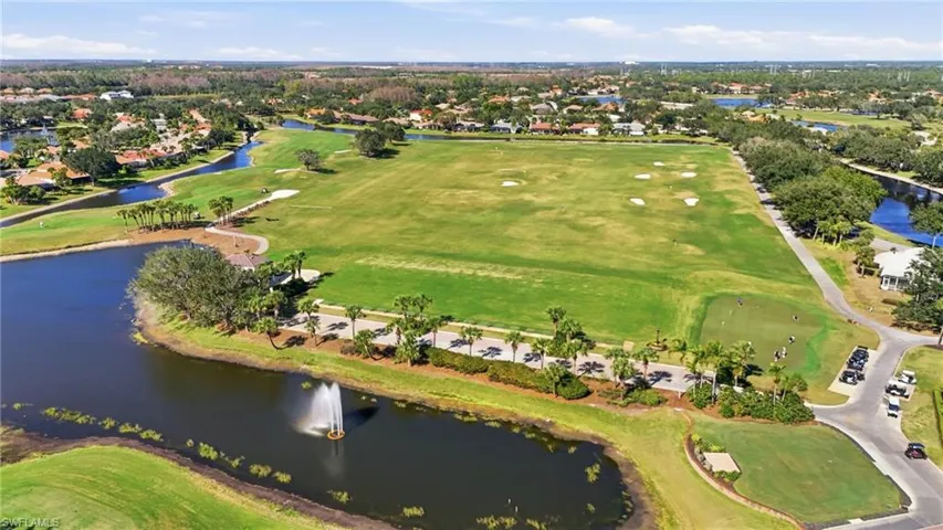 Aerial perspective of suburban area featuring a local golf course and a large body of water