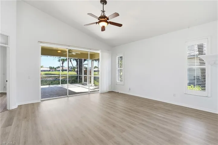 Unfurnished room with light wood-style floors, a ceiling fan, and high vaulted ceiling