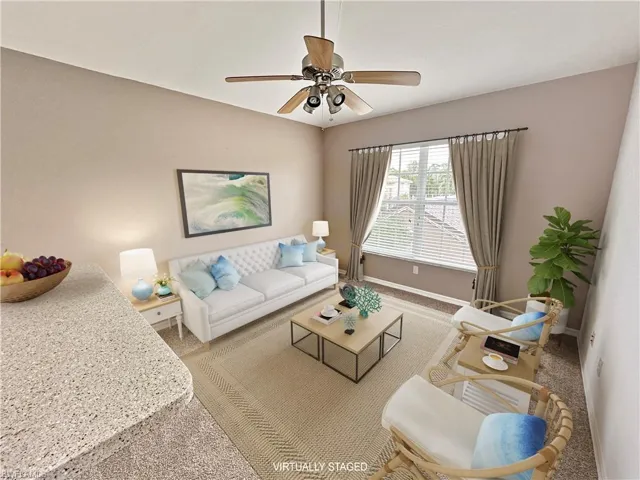 Carpeted living room featuring ceiling fan