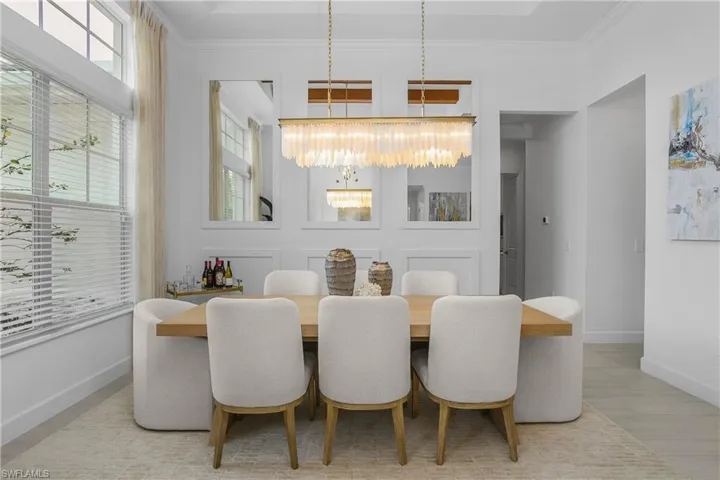 Dining room featuring a high ceiling, ornamental molding, and suspended lighting