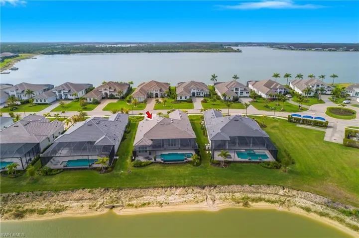 Aerial view of residential area featuring a large body of water and a pool