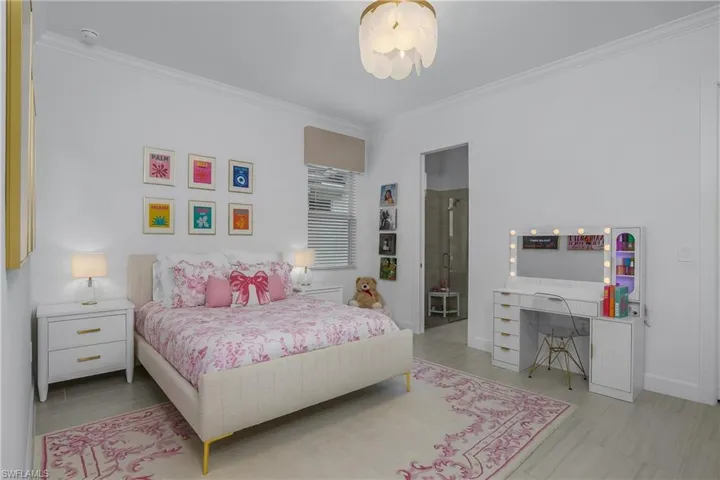 Bedroom with crown molding and baseboards