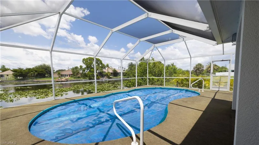 Outdoor pool with a water view, a patio, lanai, and screened pool cage