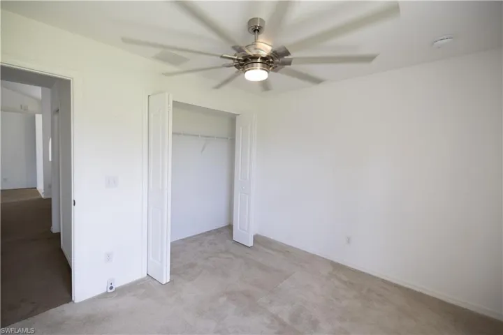 Bedroom 1 view from the windows with a closet, and a ceiling fan