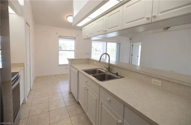 Kitchen with dishwasher, white cabinetry, stainless steel electric range, and light countertops