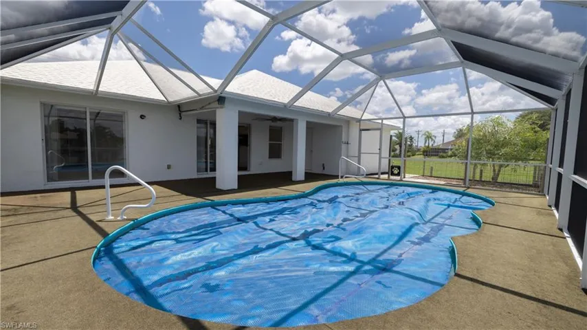 Swimming pool with a patio area, outdoor ceiling fan, and pool screened cage