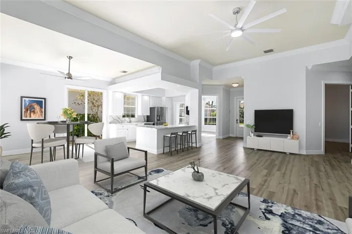 Virtual Staged - Living area with light wood-style flooring, baseboards, a ceiling fan, and ornamental molding