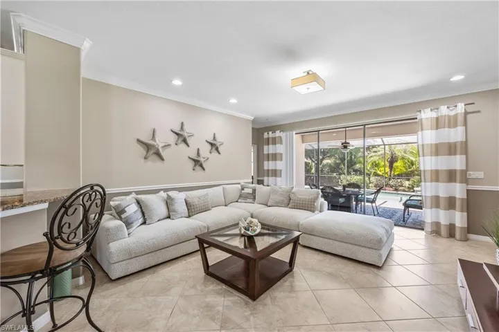 Great room featuring light tile flooring and crown moldings