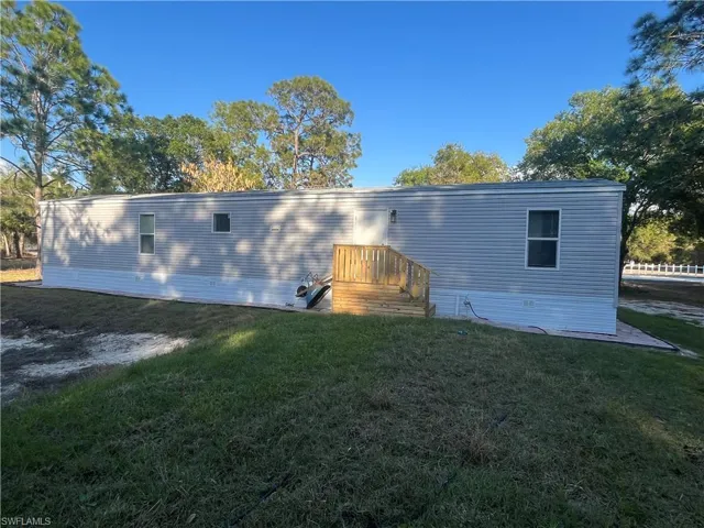 Back of house with a yard