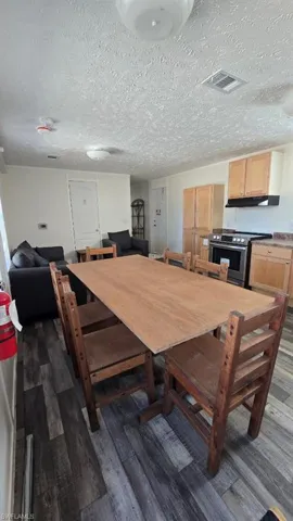 Dining room featuring a textured ceiling and dark wood finished floors