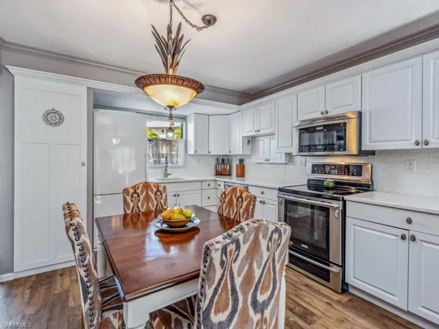 Kitchen with appliances with stainless steel finishes, white cabinetry, and Deep sink