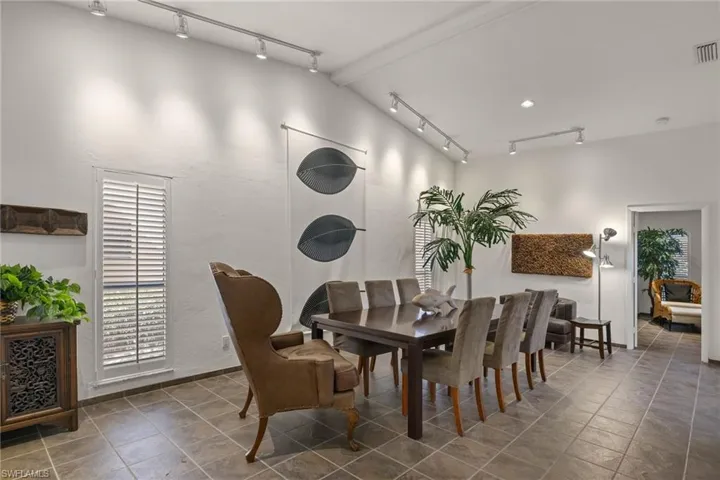 Dining area featuring track lighting and vaulted ceiling
