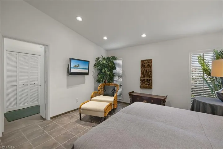 Tiled bedroom featuring lofted ceiling