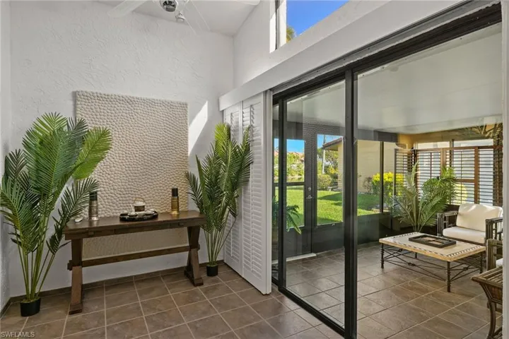 Entryway featuring ceiling fan and dark tile patterned floors