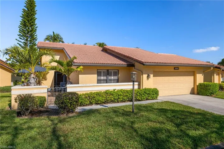 Mediterranean / spanish-style home featuring a garage and a front lawn