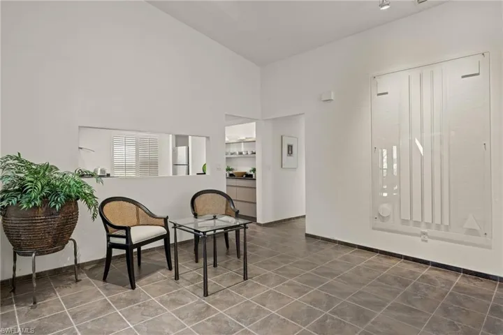 Sitting room with tile patterned floors and a high ceiling