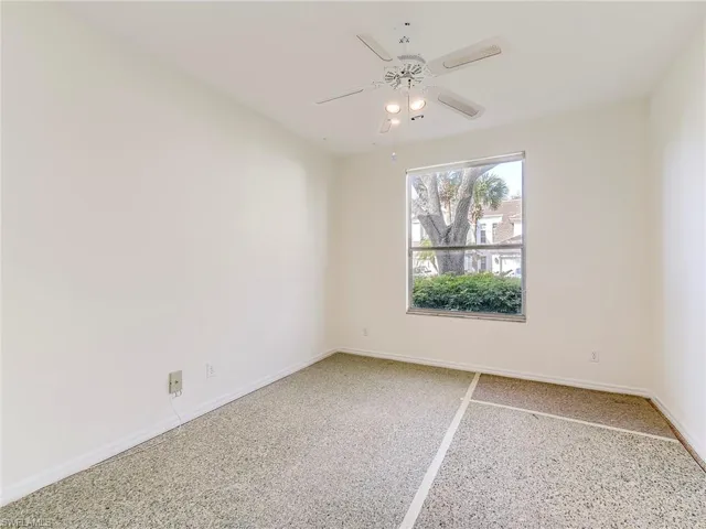 Spare room featuring dark speckled floor and ceiling fan