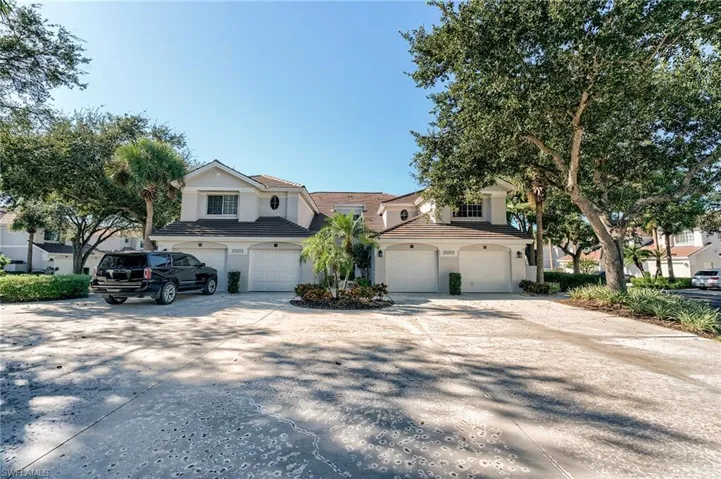Traditional-style home with concrete driveway, an attached garage, a tiled roof, and stucco siding