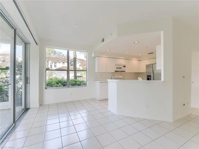 Kitchen featuring white cabinetry, white appliances, light countertops, recessed lighting, and a peninsula