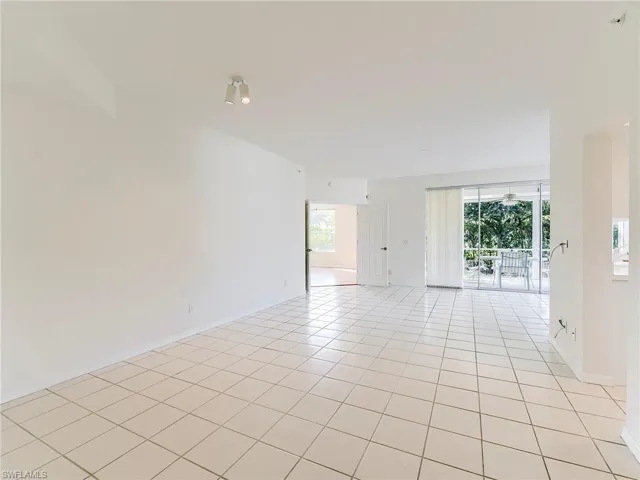 Empty room featuring light tile patterned floors and baseboards