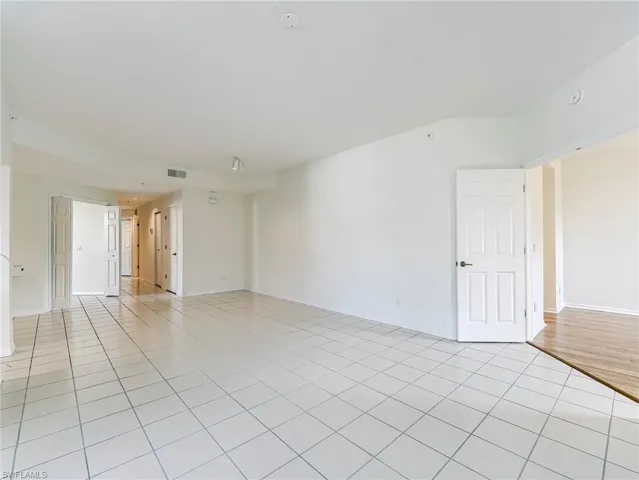 Empty room with light tile patterned flooring and baseboards