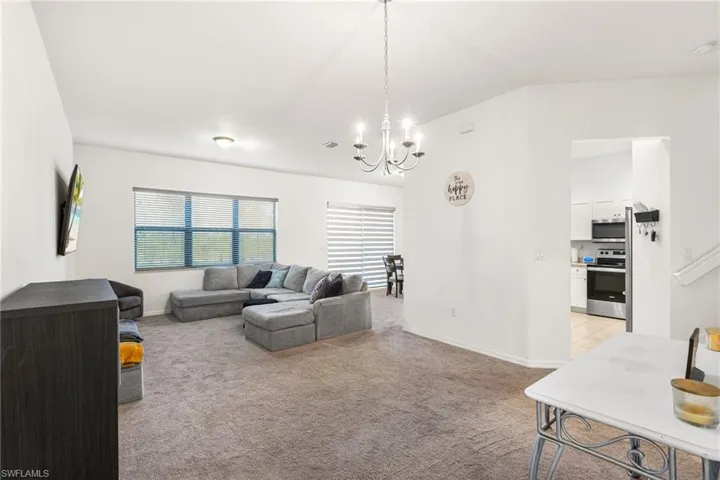 Carpeted living room featuring a wealth of natural light and a chandelier