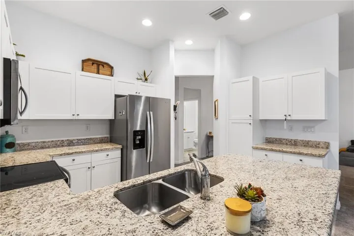 Kitchen featuring appliances with stainless steel finishes, sink, and white cabinets