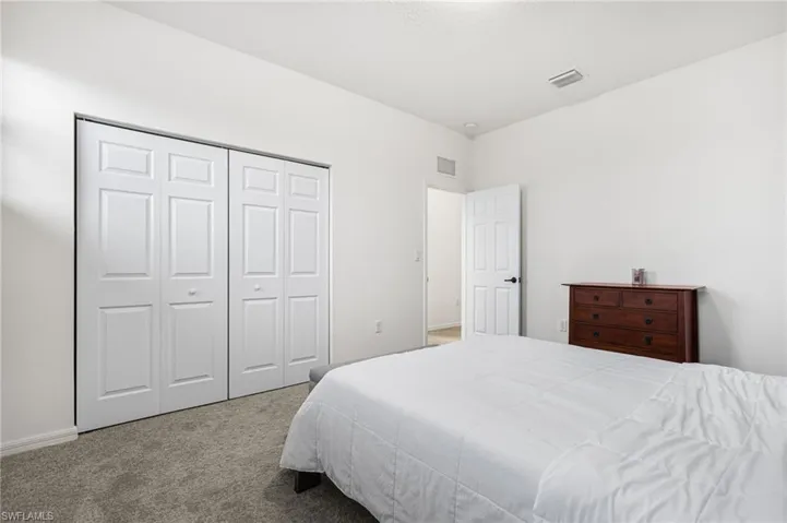 Carpeted bedroom featuring a closet