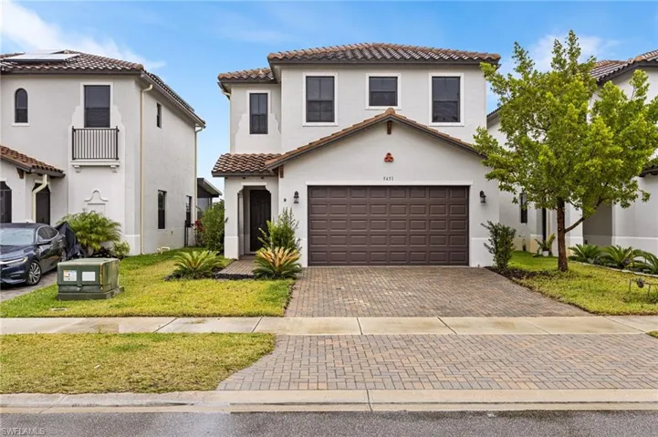 Mediterranean / spanish-style house featuring a garage and a front lawn