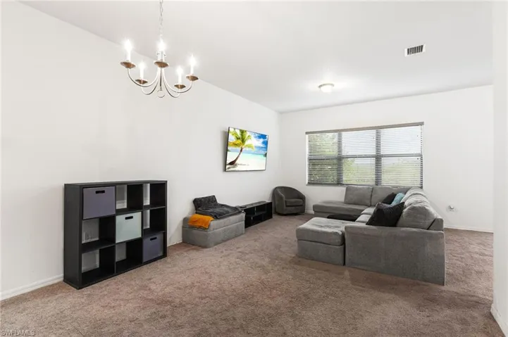 Living room featuring carpet flooring and a chandelier
